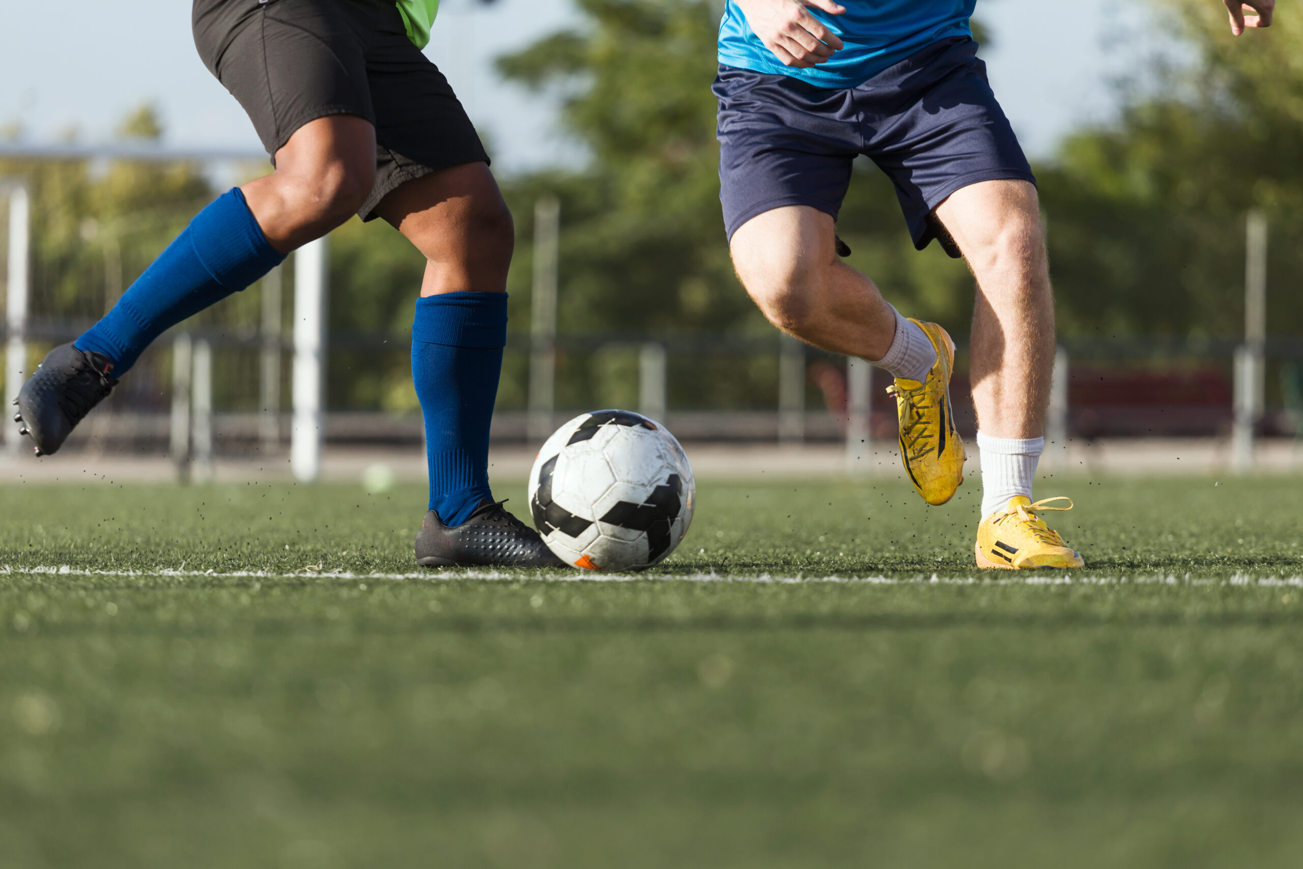 Zwei Männer wollen während eines Fußballspiel des CVJM Rüggeberg einen Ball schießen.