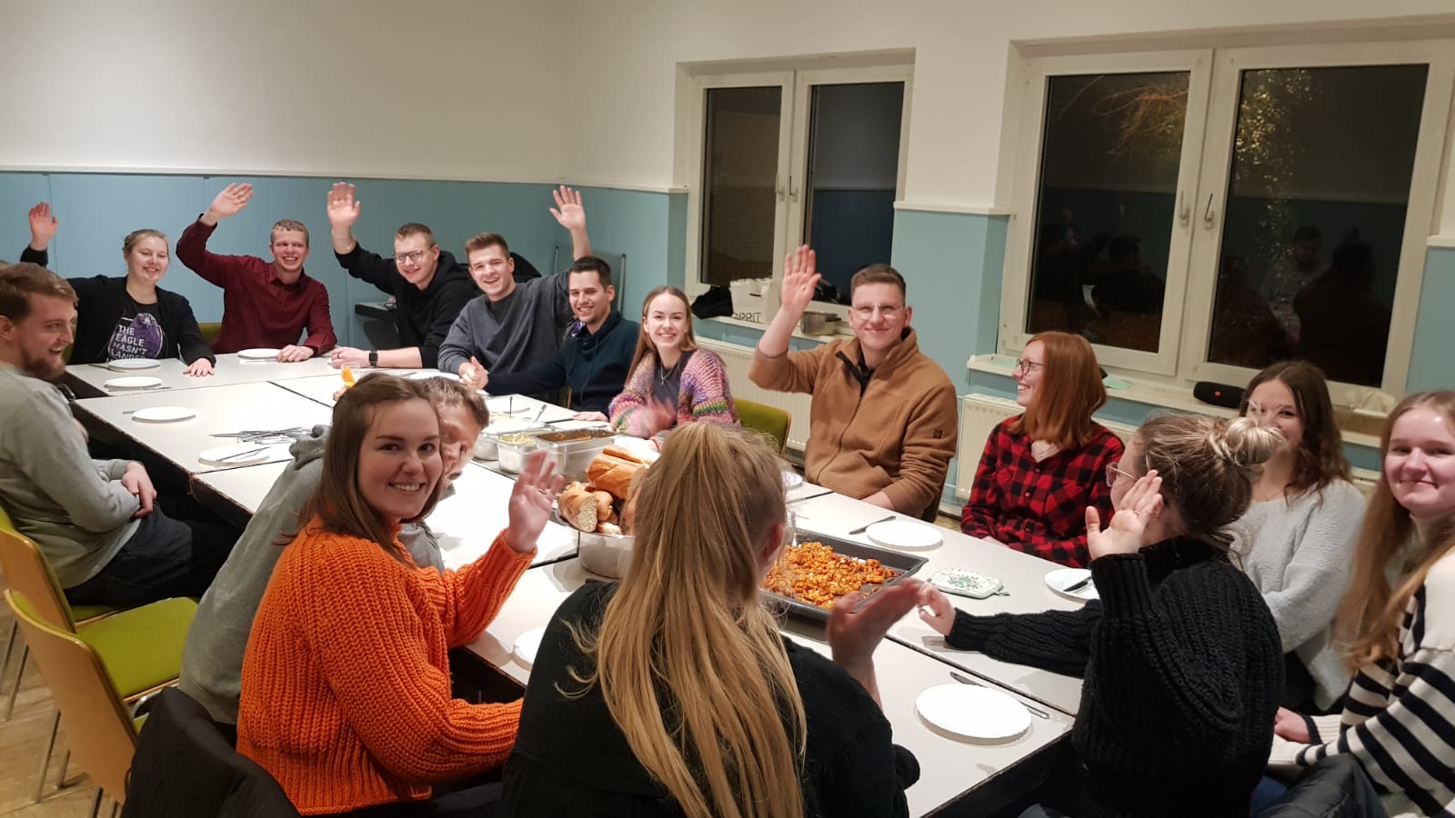 Die Besucher der Gruppe SonDays des CVJM Rüggeberg sitzen gemeinsam am Tisch und essen.